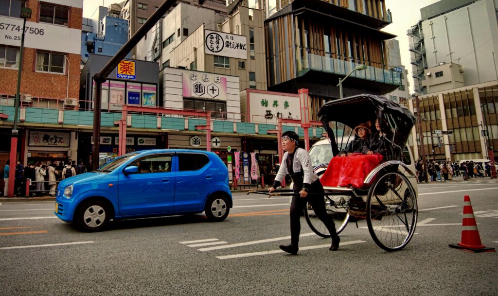 A rickshaw pulls tourists through Asakusa, Tokyo, blending tradition with modern city life.