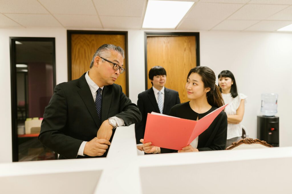 Business professionals discussing work documents in an office setting, showcasing teamwork.